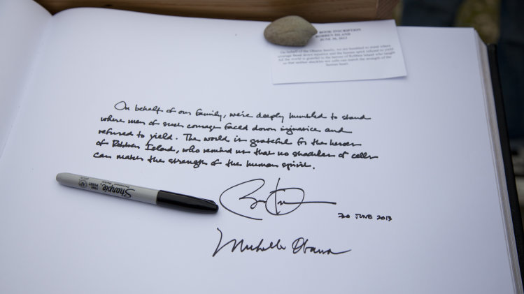 A note written by U.S. President Barack Obama and signed by both him and first lady Michelle Obama after they toured Robben Island, is seen on a guestbook at Robben Island, South Africa, Sunday, June 30, 2013. Robben Island is an historic Apartheid-era prison that held black political prisoners including former South African president and anti-apartheid hero Nelson Mandela. (AP Photo/Evan Vucci)