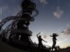 In this Friday, Aug. 3, 2012 photo, two women dance to music on loudspeakers under the Orbit attraction at Olympic Park during the 2012 Summer Olympics, in London. (AP Photo/Charlie Riedel)