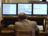 A trader sits in front of computer screens at the stock exchange in Madrid