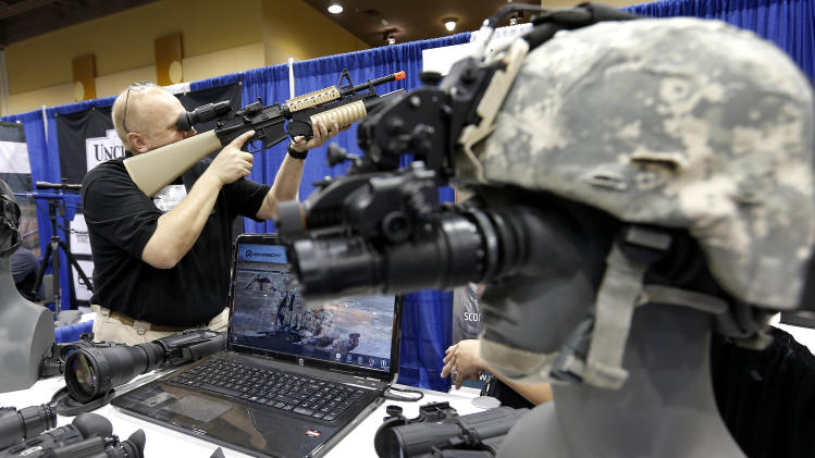 Allen Harding, of Armasight, demonstrates his products Tuesday, March 12, 2013 at the Border Security Expo in Phoenix. More than 180 companies are exhibiting their security products despite automatic spending cuts that are affecting every federal government agency due to the government sequestration. (AP Photo/Matt York)