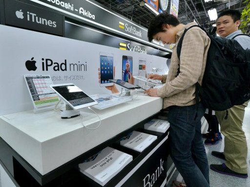 Customers check the Apple's tablet iPads at an electronics shop on May 31, 2013
