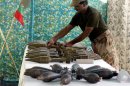 A Pakistani army soldier arranges weapons reportedly recovered from hideouts of militants in tribal areas, as they are displayed in Peshawar, Pakistan on Wednesday, Aug. 29, 2012. (AP Photo/Mohammad Sajjad)