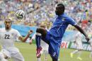FILE- In this file photo dated Tuesday, June 24, 2014, Italy's Mario Balotelli, right, kicks the ball over Uruguay's Martin Caceres during the group D World Cup soccer match between Italy and Uruguay at the Arena das Dunas in Natal, Brazil. England's Liverpool soccer club announced Monday Aug. 25, 2014, it has completed the signing of Italy striker Mario Balotelli from AC Milan. (AP Photo/Ricardo Mazalan, FILE)