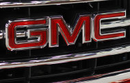 <p>               This Oct. 28, 2011 photo, shows the GMC nameplate on the grille of a 2012 GMC Sierra at the 41st annual South Florida International Auto Show, in Miami Beach, Fla. General Motors said Wednesday, Nov. 9, 2011, it earned $1.7 billion in the third quarter, down 15 percent from a year earlier. (AP Photo/Lynne Sladky)