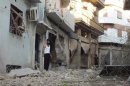 Syrian residents inspect houses destroyed by what they said was heavy shelling from Syrian President al-Assad forces in Banisaba'i area in Homs