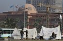 Egyptians chat outside their tents in front of the Egyptian museum in Tahrir Square, in Cairo, Egypt, Saturday, April 27, 2013. Egypt's economy, particularly the vital tourism sector, has been hit hard by the instability that has followed the 2011 uprising that forced longtime autocratic ruler Hosni Mubarak from power. (AP Photo/ Amr Nabil)
