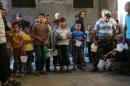 Syrians wait to receive meals distributed by the "Syria charity" NGO to impoverished families during the Muslim holy fasting month of Ramadan on June 11, 2016 in a rebel-held neighbourhood of the northern city Aleppo