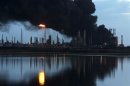 A column of smoke rises as fuel storage tanks are seen on fire at Amuay oil refinery in Punto Fijo in the Peninsula of Paraguana