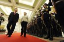 German Chancellor Angela Merkel (C) and Chinese Premier Wen Jiabao review an honor guard