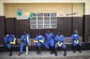 Health workers rest outside a quarantine zone at a Red Cross facility in the town of Koidu