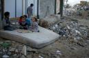 Palestinian children play on a mattress near ruins of houses which witnesses said were destroyed by Israeli shelling during most recent conflict in Gaza City