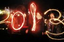 Katy Saunders, left, Alex Mueller, center left, Rebekka Frank and Arina Motamedi, right, play with sparklers ahead of welcoming in the new year during the 2013 Edinburgh Hogmanay celebrations, Scotland, Monday December 31, 2012. See PA story SOCIAL NewYear. (AP Photo/PA,Danny Lawson)UNITED KINGDOM OUT