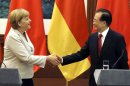 German Chancellor Angela Merkel, left, shakes hands with Chinese Premier Wen Jiabao after a joint press conference at the Great Hall of the People in Beijing Thursday, Aug. 30, 2012. (AP Photo/Ng Han Guan)