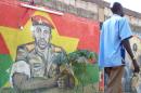 A man walks past a painting featuring military captain Thomas Sankara (L) in Ouagadougou on November 18, 2010