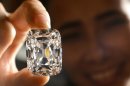 FILE- In this Oct. 4, 2012, file photo, a model holds the Archduke Joseph Diamond, a historical diamond, during a Christie's auction preview, in Geneva, Switzerland. On Tuesday, Nov. 13, 2012 Christie's is selling the Archduke Joseph Diamond, one of the rarest and most famous. The 76.02 carat diamond, with perfect color and internally flawless clarity, came from the ancient Golconda mines in India. It is expected to sell for more than $15 million. In 1993, Christie's auctioned it in Geneva where it sold for $ 6.5 million. (AP Photo/Keystone, Laurent Gillieron, File)