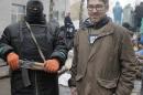 In this photo taken on Sunday, April 13, 2014, a U.S. reporter Simon Ostrovsky, right, stands with a Pro-Russian gunman at seized police station in the eastern Ukraine town of Slovyansk. Pro-Russian gunmen in eastern Ukraine admitted on Wednesday April 23, 2014, that they are holding captive American journalist for Vice News Simon Ostrovsky who has not been seen since early Tuesday. Ostrovsky has been covering the crisis in Ukraine for some weeks and was reporting about groups of masked gunmen seizing government buildings in eastern Ukrainian. (AP Photo/Efrem Lukatsky)