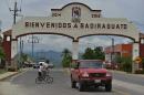 In this July 20, 2015 photo, a car drives past the entrance to the town of Badiraguato, Mexico. Tucked into the foothills where the coastal stretches of flat corn and tomato fields meet the imposing mountains of the Sierra Madre, Badiraguato, the hometown of drug lord Joaquin 