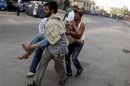 Protesters, who support former Egyptian President Mohamed Mursi, carry an injured man during clashes outside the Republican Guard building in Cairo