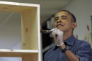 President Barack Obama stains a bookshelf at Burrville Elementary School in Washington, Saturday, Jan. 19, 2013, as the first family participated in a community service project for the National Day of Service, part of the 57th Presidential Inauguration. (AP Photo/Susan Walsh)
