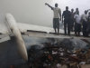 People gather at the site of a plane crash in Lagos, Nigeria, Sunday, June 3, 2012. A passenger plane carrying more than 150 people crashed in Nigeria's largest city on Sunday, government officials said. Firefighters pulled at least one body from a building that was damaged by the crash and searched for survivors as several charred corpses could be seen in the rubble.(AP Photo/Sunday Alamba)