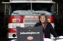 Monica Kelsey, firefighter and medic who is president of Safe Haven Baby Boxes Inc., poses with a prototype of a baby box, where parents could surrender their newborns anonymously, outside her fire station in Woodburn, Ind., Thursday, Feb. 26, 2015. The box is actually a newborn incubator, or baby box, and it could be showing up soon at Indiana hospitals, fire stations, churches and other selected sites under legislation that would give mothers in crisis a way to surrender their children safely and anonymously. (AP Photo/Michael Conroy)