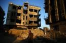 A fighter from the Free Syrian Army's Al Rahman legion walks past damaged buildings in the rebel held Jobar, a suburb of Damascus