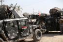 Iraqi soldiers stand near military vehicles on October 4, 2014 in the Sunni town of Dhuluiyah, some 75 kms north of Baghdad
