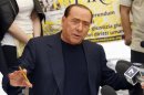 PDL leader Silvio Berlusconi talks with reporters as he signs a referendum on justice reforms and human rights in downtown Rome
