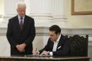 Leftist Syriza leader and winner of Greek general election Alexis Tsipras signs documents as he is sworn in as prime minister during a ceremony at the presidential palace in Athens