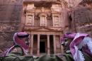 In this Tuesday, March 24, 2015 photo, Jordanian royal desert forces stand guard in front of Al Khazneh, Arabic for the Treasury, the most dramatic of many facades carved into the mountains, in the ancient city of Petra, Jordan. It's high season in Petra, the ancient city hewn from rose-colored rock and Jordan's biggest tourist draw. Yet nearby hotels stand virtually empty these days and only a trickle of tourists make their way through a landmark canyon to the Treasury building where scenes of one of the "Indiana Jones" movies were filmed. (AP Photo/Raad Adayleh)