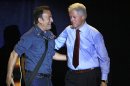 Former President Bill Clinton greets singer/songwriter Bruce Springsteen at a campaign event for President Barack Obama, Thursday, Oct. 18, 2012, in Parma, Ohio. (AP Photo/Tony Dejak)