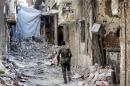 A fighter from the Popular Front for the Liberation of Palestine General Command walks past destroyed buildings in the Yarmouk refugee camp in the Syrian capital Damascus on September 12, 2013