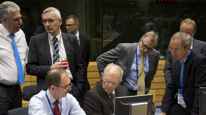 German Finance Minister Wolfgang Schaeuble, sitting center, goes over papers with members of his delegation during a round table meeting of eurogroup finance ministers at the EU Lex building in Brussels on Sunday, July 12, 2015. Greece has another chance Sunday to convince skeptical European creditors that it can be trusted to enact wide-ranging economic reforms which would safeguard its future in the common euro currency. (AP Photo/Virginia Mayo)