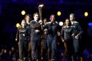 Seven young athletes carry the Olympic torch into the opening ceremony of the London 2012 Olympic Games
