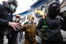 Pro-European integration protesters carry Molotov cocktails during clashes with police in Kiev
