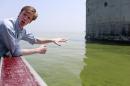 Collin O'Mara, president and CEO of the National Wildlife Federation, gestures as he talks about algae near the City of Toledo water intake crib, Sunday, Aug. 3, 2014, in Lake Erie, about 2.5 miles off the shore of Curtice, Ohio. More tests are needed to ensure that toxins are out of Toledo's water supply, the mayor said Sunday, instructing the 400,000 people in the region to avoid drinking tap water for a second day. Toledo officials issued the warning early Saturday after tests at one treatment plant showed two sample readings for microcystin above the standard for consumption, possibly because of algae on Lake Erie. (AP Photo/Haraz N. Ghanbari)