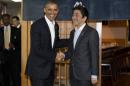 President Barack Obama and Japanese Prime Minister Shinzo Abe shake hands before having dinner at Sukiyabashi Jiro sushi restaurant in Tokyo, Wednesday, April 23, 2014. Opening a four-country swing through the Asia-Pacific region, Obama is aiming to promote the U.S. as a committed economic, military and political partner, but the West's dispute with Russia over Ukraine threatens to cast a shadow over the president's sales mission. (AP Photo/Carolyn Kaster)