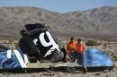 Sheriffs' deputies look at wreckage from the crash of Virgin Galactic's SpaceShipTwo near Cantil, California