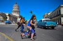 A woman wearing leggings with the colours of the US flag walks along a street of Havana on February 18, 2015