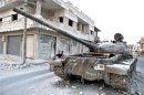 A destroyed tank of Syrian President Bashar al Assad's forces is seen after clashes with the Free Syrian Army in the Rasten area, near Homs