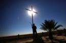 A member of the Iraqi Christian forces Kataeb Babylon (Babylon Brigades) stands guard beneath a cross at the Mar Behnam Syriac Catholic monastery in Khidr Ilyas