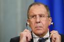 Russian Foreign Minister Lavrov adjusts his headphones during joint news conference with his Italian counterpart Gentiloni following their meeting in Moscow