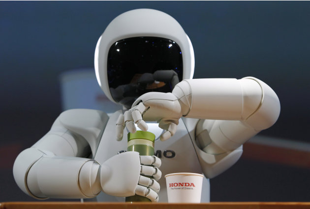 Honda Motor Co&#39;s Asimo humanoid robot opens the top of a bottle at the 42nd Tokyo Motor Show