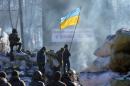 Anti-government opposition activists stand guard at a barricade in the Ukrainian capital of Kiev on February 2, 2014