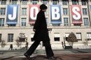 Woman walks past "Jobs" banner hung above Chamber of Commerce in Washington