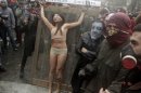 A group of actors perform a woman being tortured during a protest against the premiere of a documentary about the late Gen. Augusto Pinochet in Santiago, Chile, Sunday June 10, 2012. Police used tear gas and water cannons to try to disperse hundreds of anti-Pinochet demonstrators against the documentary about the run-up to his dictatorship years and casting him as a national hero who saved Chile from communism,(AP Photo/Luis Hidalgo)