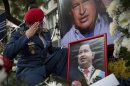 A Venezuelan army officer salutes a photo of Venezuela's late President Hugo Chavez at a makeshift memorial outside the Venezuelan Embassy in Buenos Aires, Argentina on Saturday, March 9, 2013. Chavez died on March 5, 2013 after a nearly two-year bout with cancer. (AP Photo/Victor R. Caivano)
