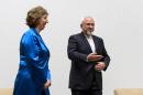 EU High Representative for Foreign Affairs Catherine Ashton, left, walks next to Iranian Foreign Minister Mohammad Javad Zarif during a photo opportunity prior to the start of two days of closed-door nuclear talks, Tuesday, Oct. 15, 2013, at the United Nations offices in Geneva. Iran's overtures to the West are being tested as the United States and its partners sit down for the first talks on Tehran's nuclear program since the election of a reformist Iranian president. Negotiations between Iran and the U.S., Russia, China, Britain, France and Germany began Tuesday morning. (AP Photo/Fabrice Coffrini, Pool)