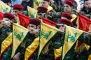 Members of Lebanon's Shiite movement Hezbollah hold their flags on March 1, 2016, in the southern town of Kfour, during a funeral for a Hezbollah fighter