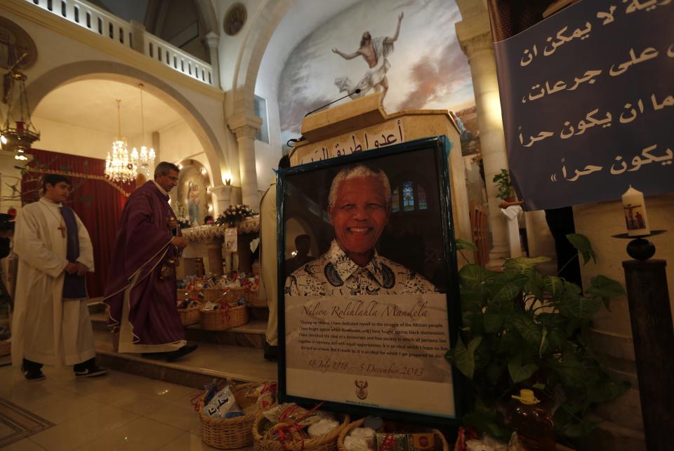 A poster depicting former South African President Mandela is displayed during a special service in his honour at the Holy Family Church in the West Bank city of Ramallah